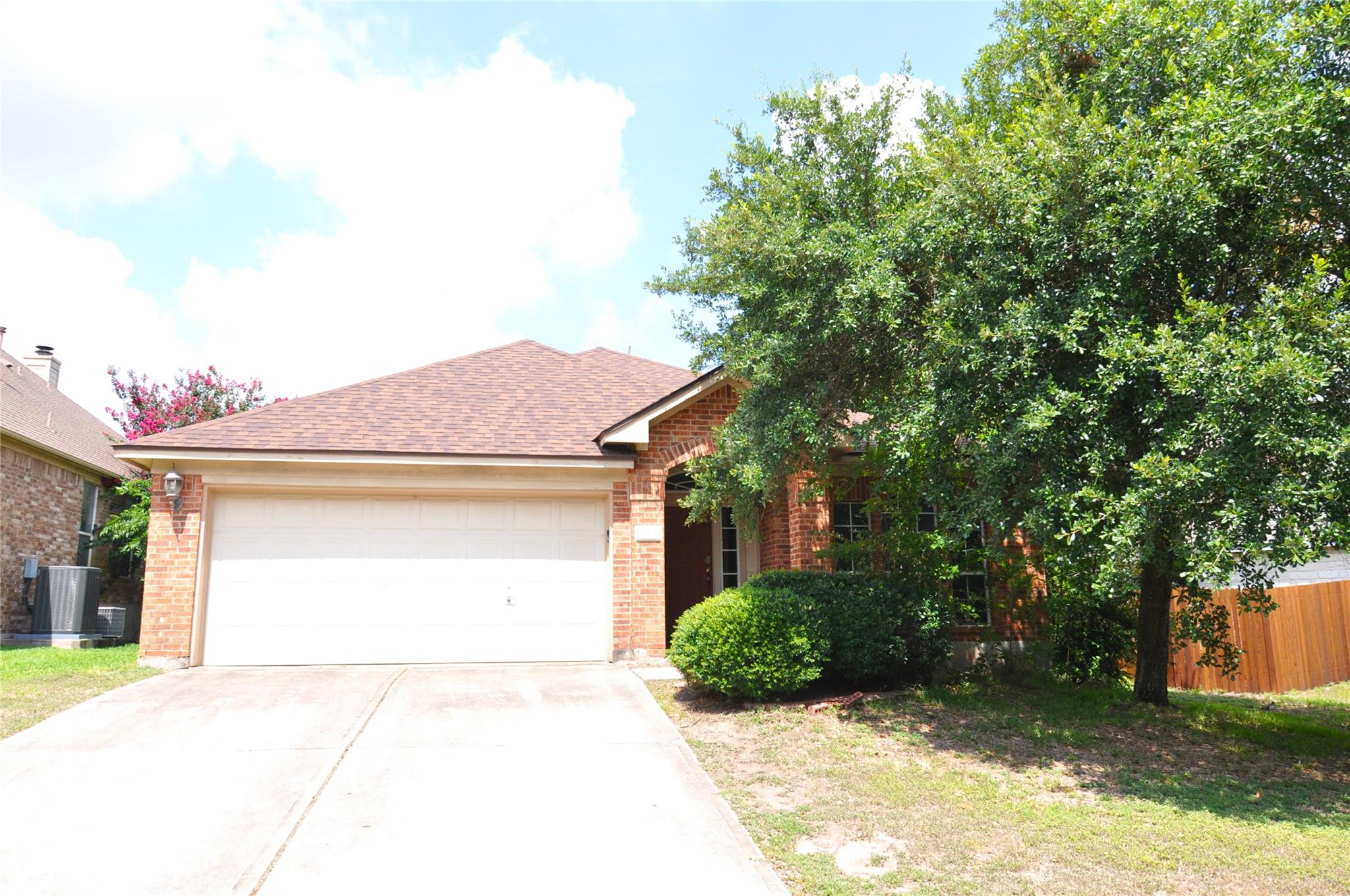 Mature trees frame the classic brick exterior and