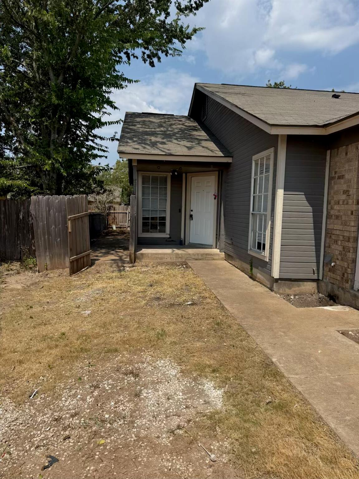A concrete walkway leads to the covered front ent