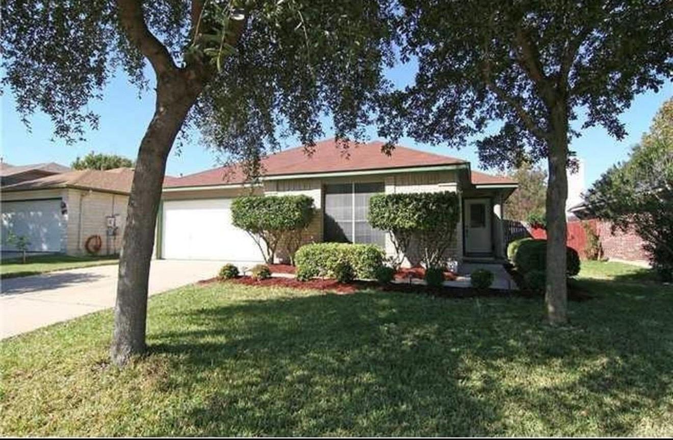 Mature trees shade a welcoming grass lawn leading