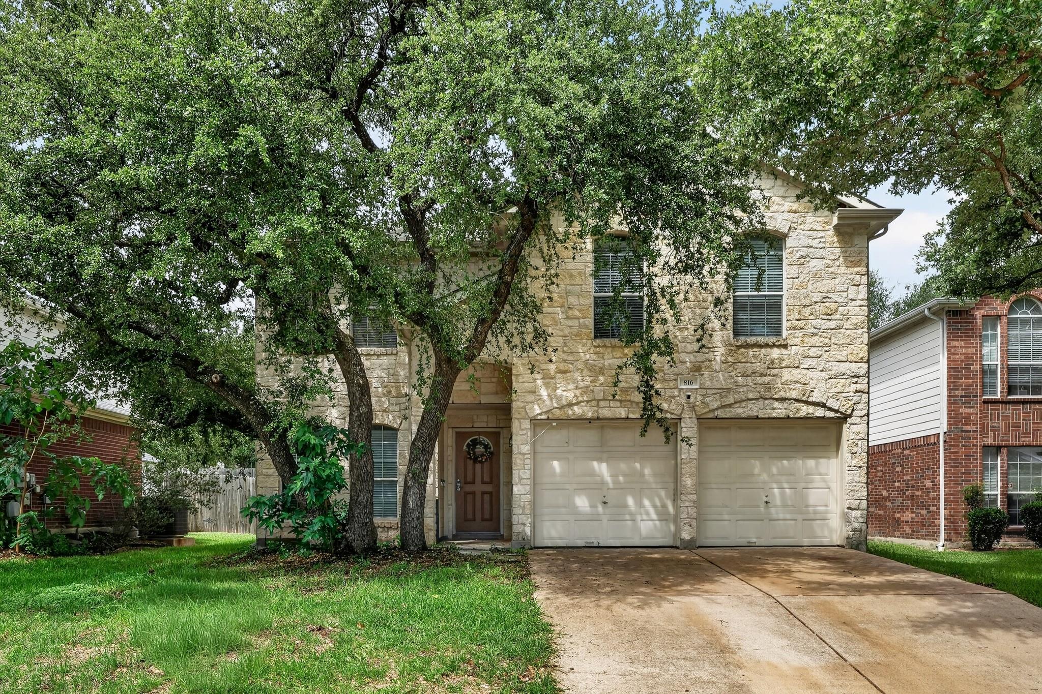Stone facade residence featuring a two-car garage