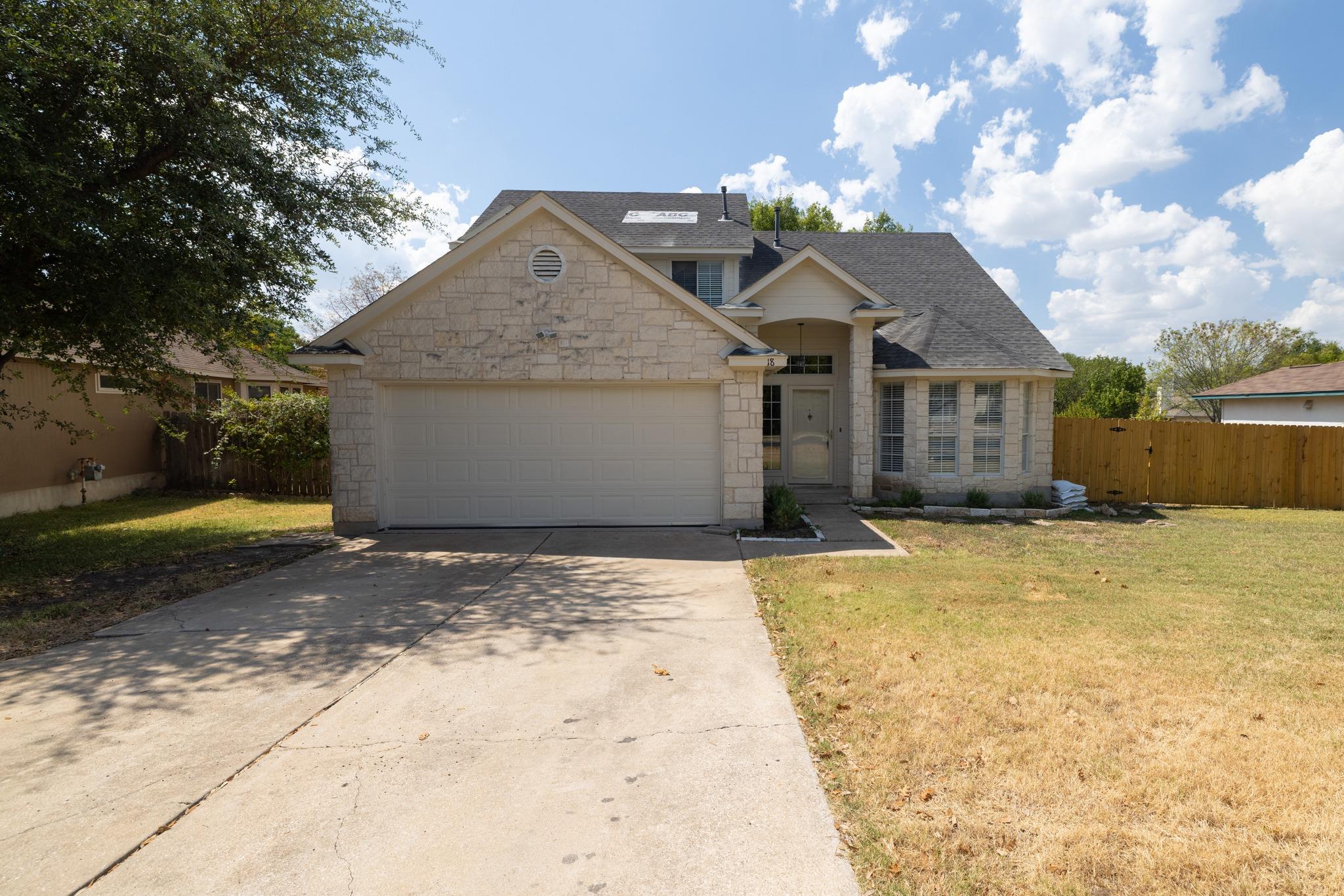 A classic stone exterior and concrete driveway de