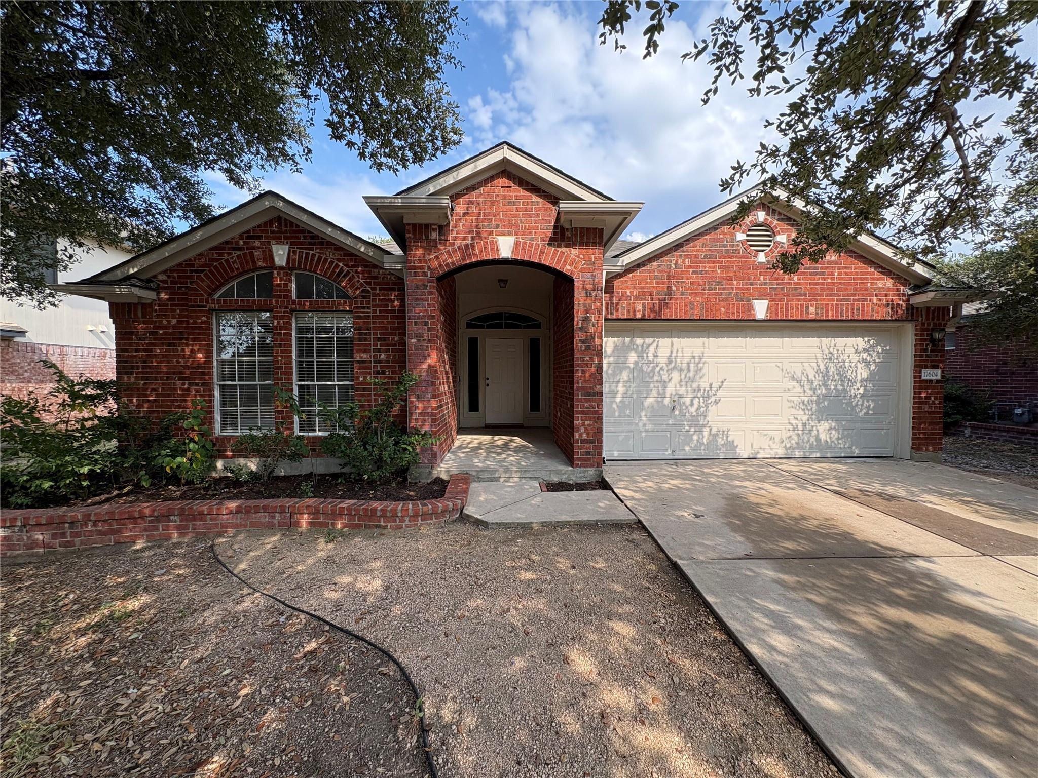 Mature trees shade a classic brick exterior with 