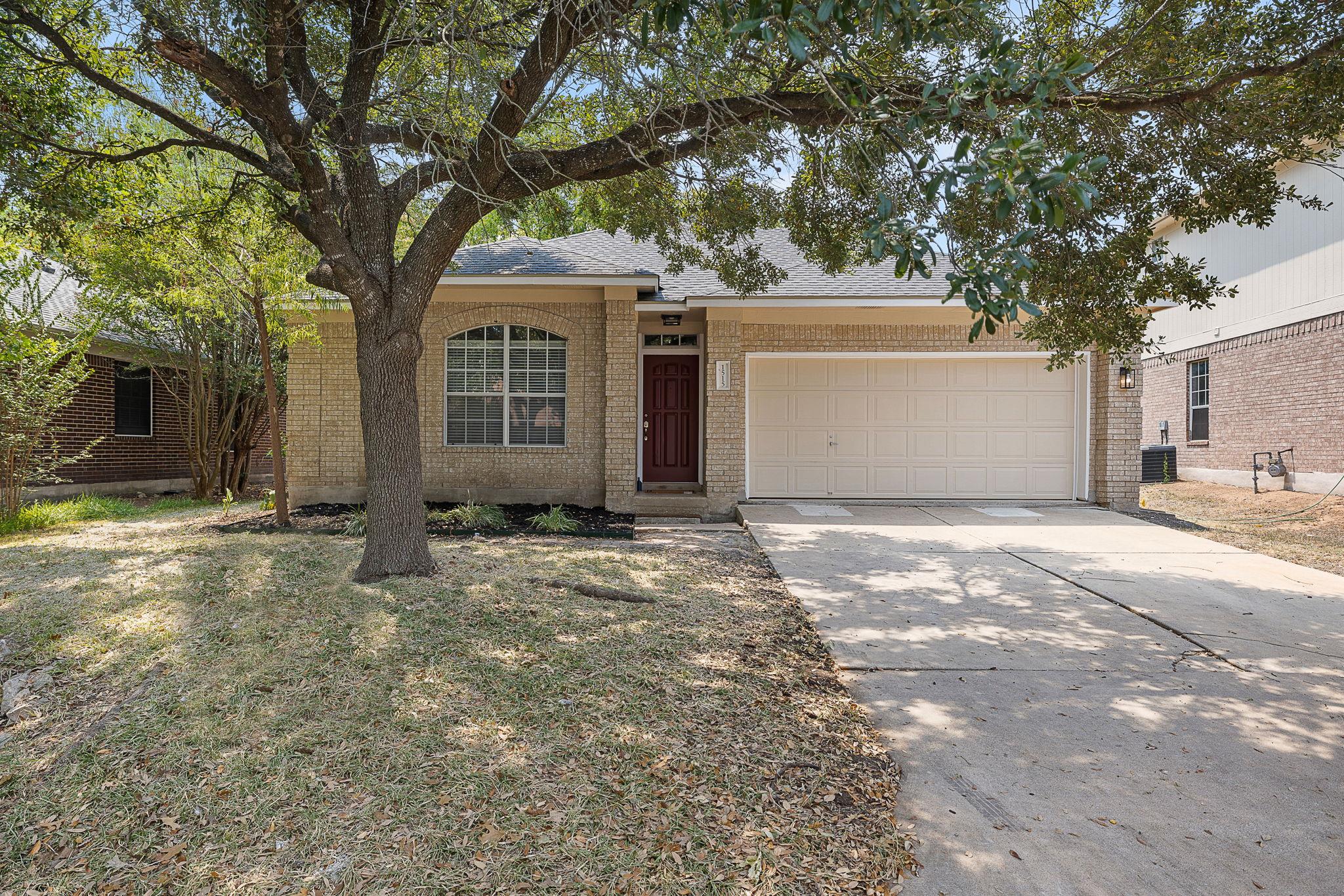 Mature trees shade a classic brick exterior and p
