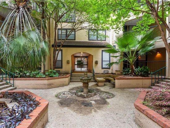 Lush plantings and a stone fountain frame a share
