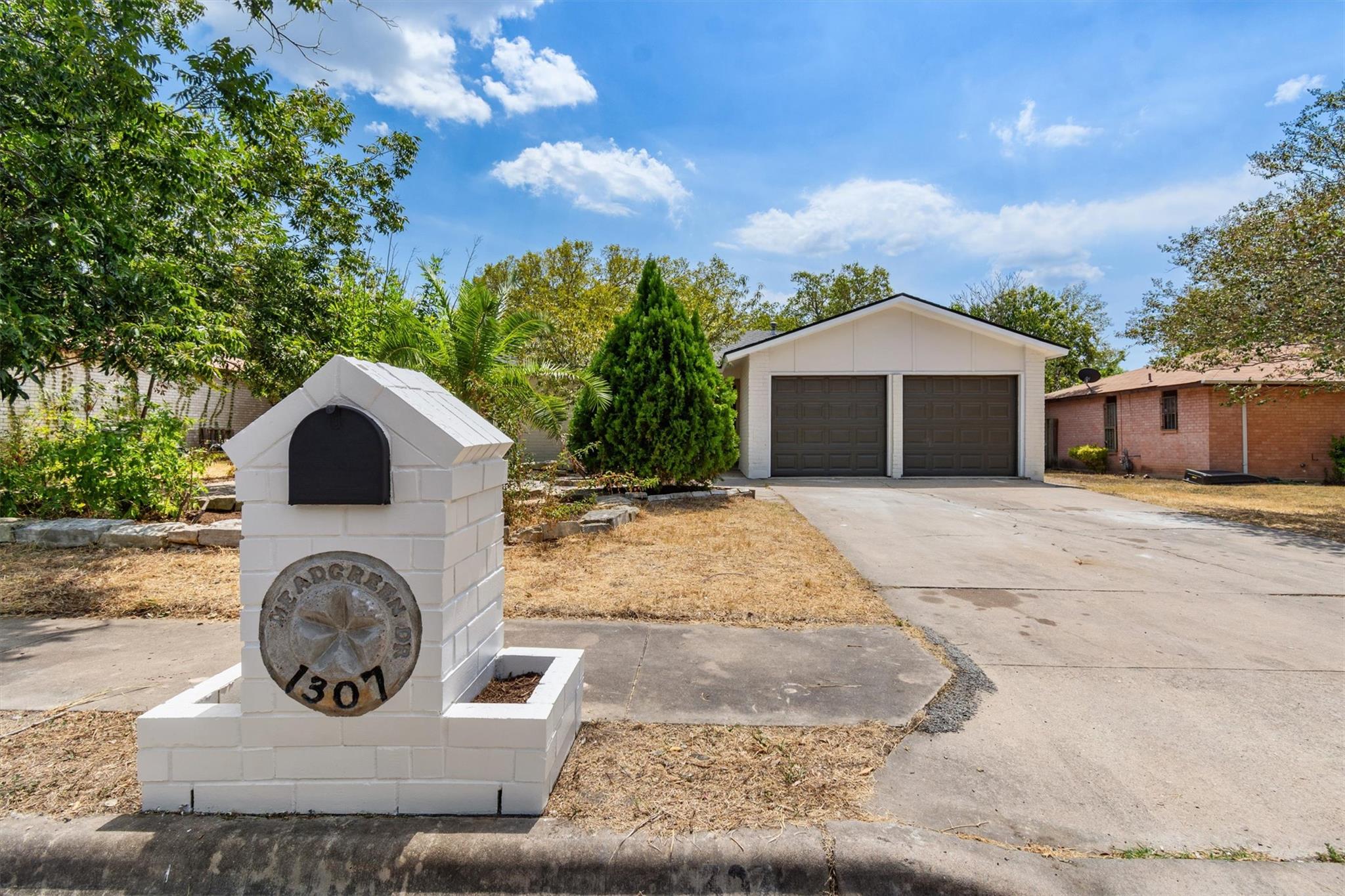 A spacious concrete driveway leads toward a class