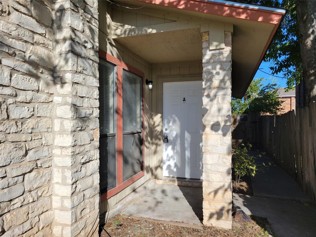 A covered entry features stone columns and a conc