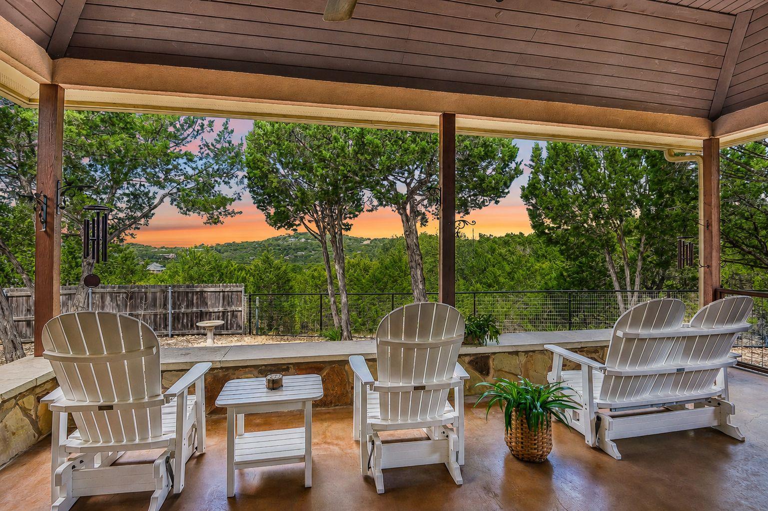 A spacious covered patio looks out over mature tr