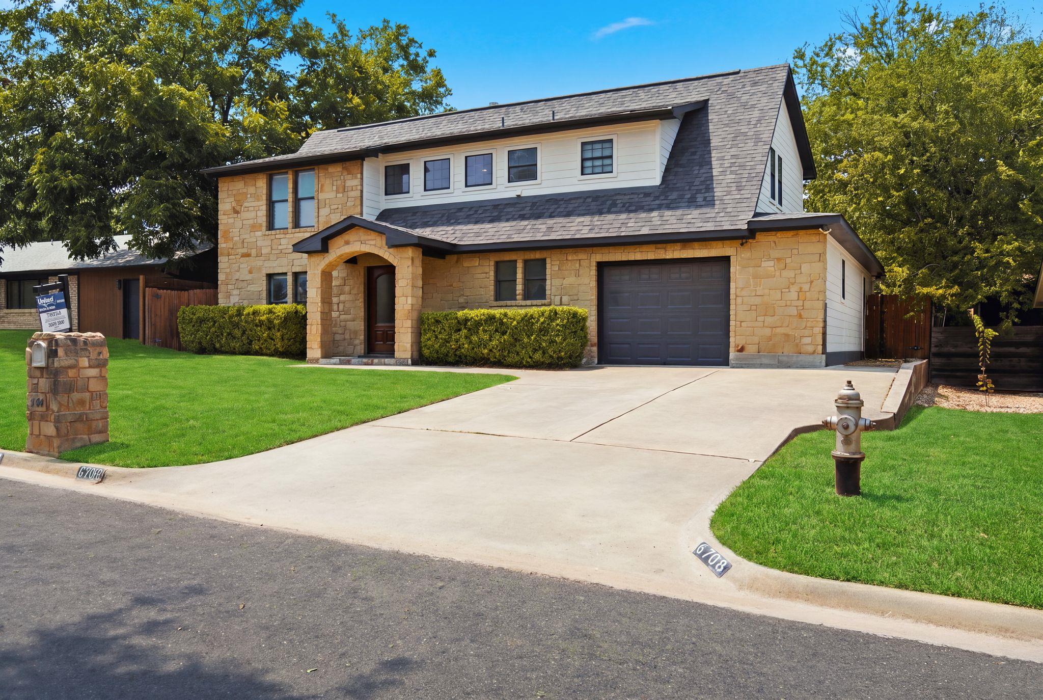 Natural stone masonry and a concrete driveway def