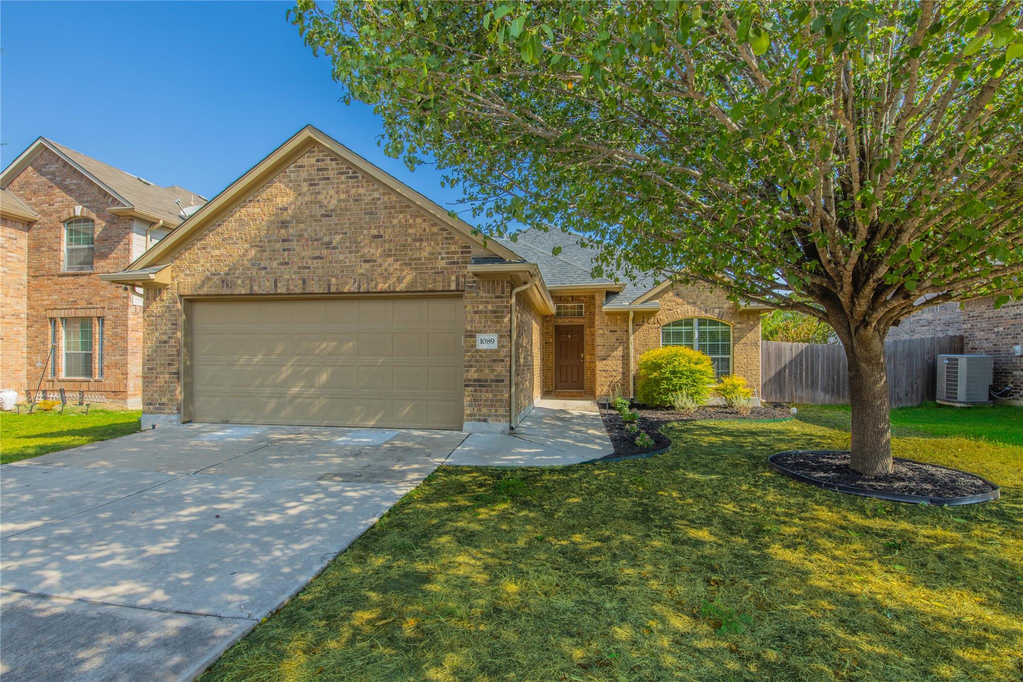 A classic brick exterior and concrete driveway ar