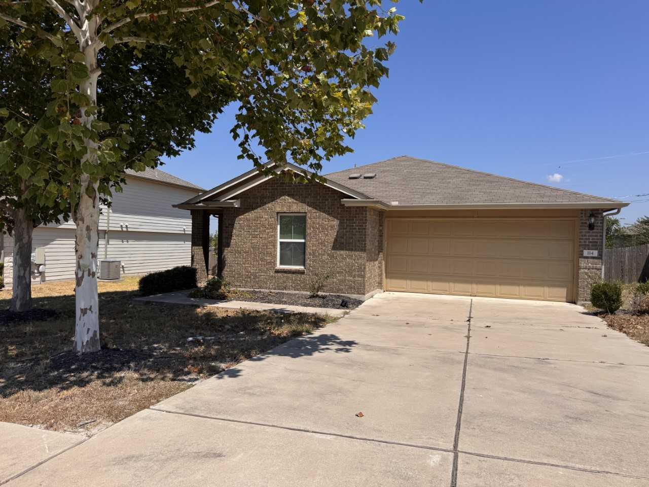 A classic brick exterior and concrete driveway de