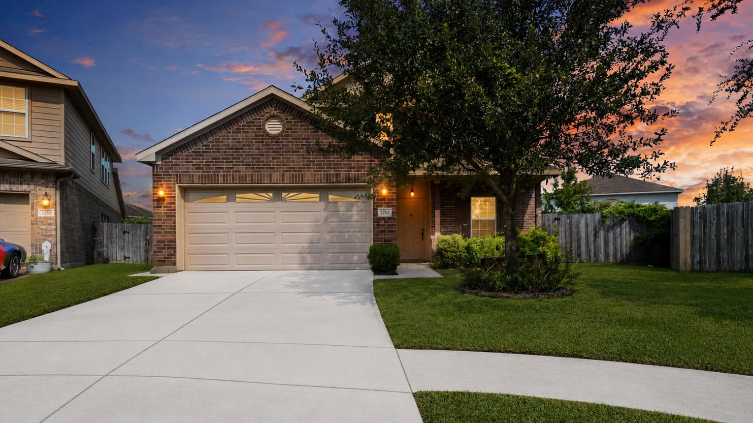 An inviting brick facade and manicured lawn creat