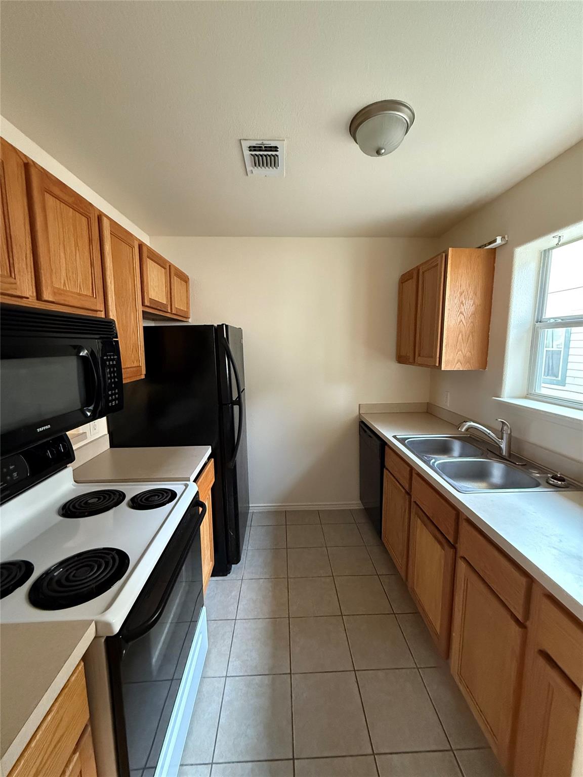 Ample wooden cabinetry and classic tile flooring 