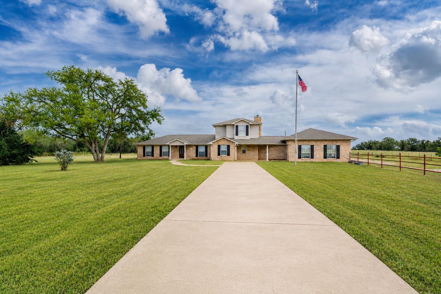A long concrete driveway guides the eye toward th
