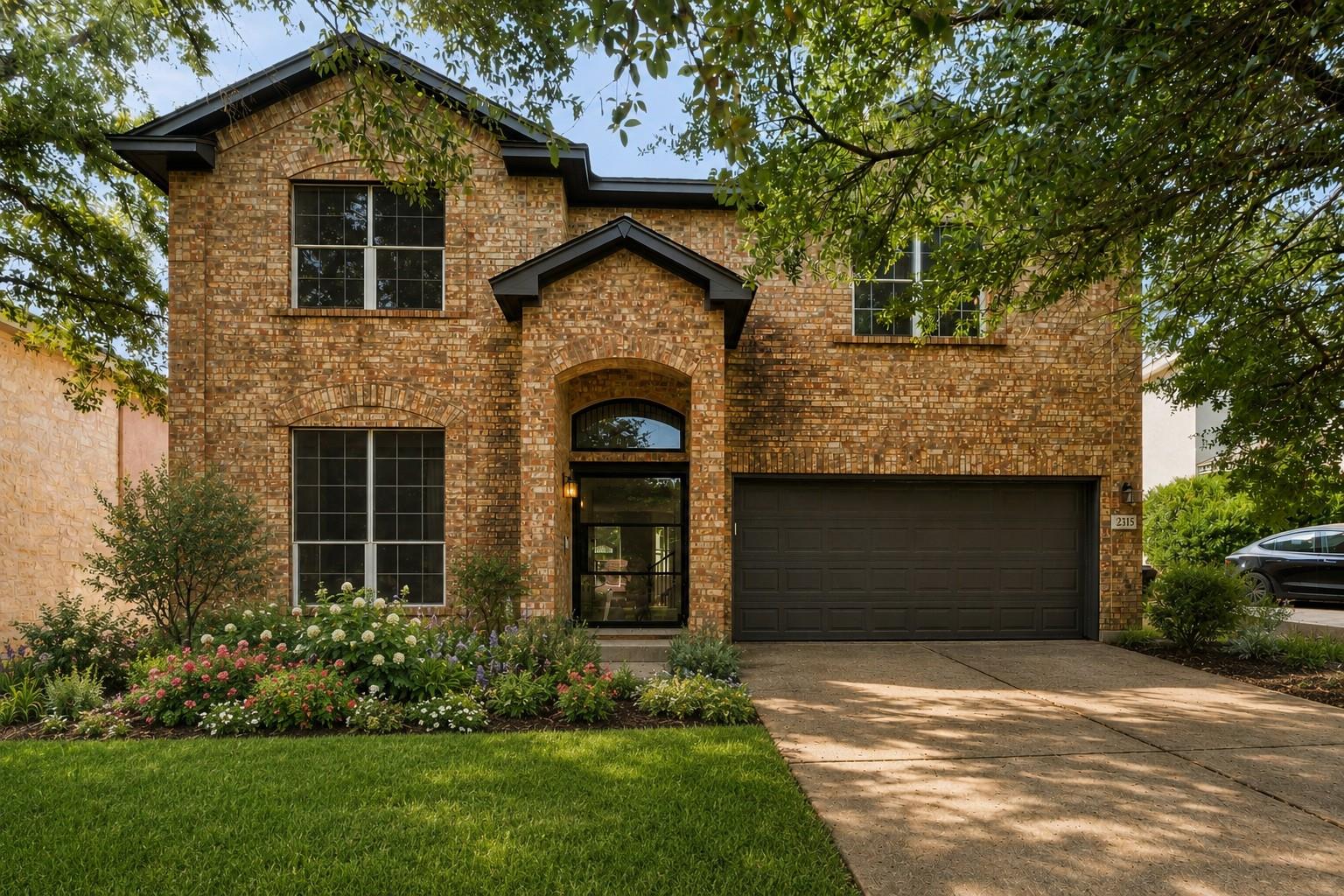 Mature trees shade a classic brick elevation with