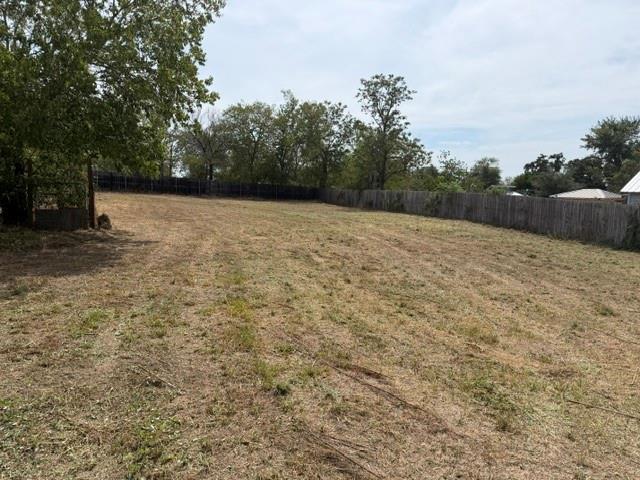 A spacious, fully fenced cleared lot is bordered 
