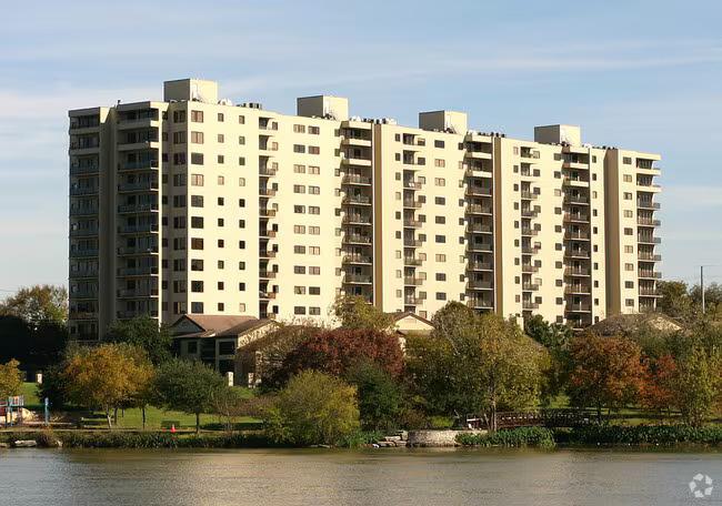 A high-rise residential building rises above a se