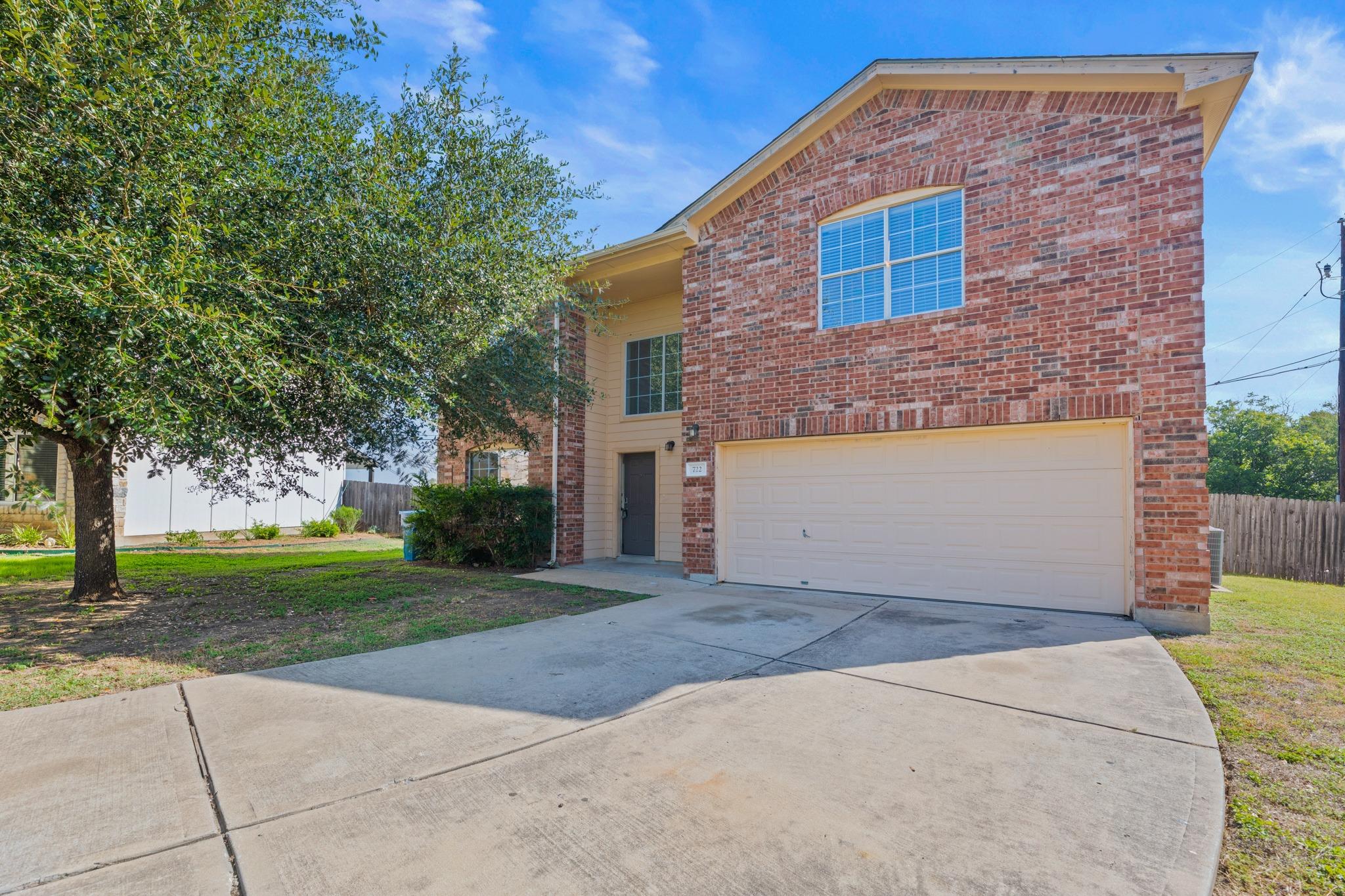 A wide concrete driveway leads to this classic br