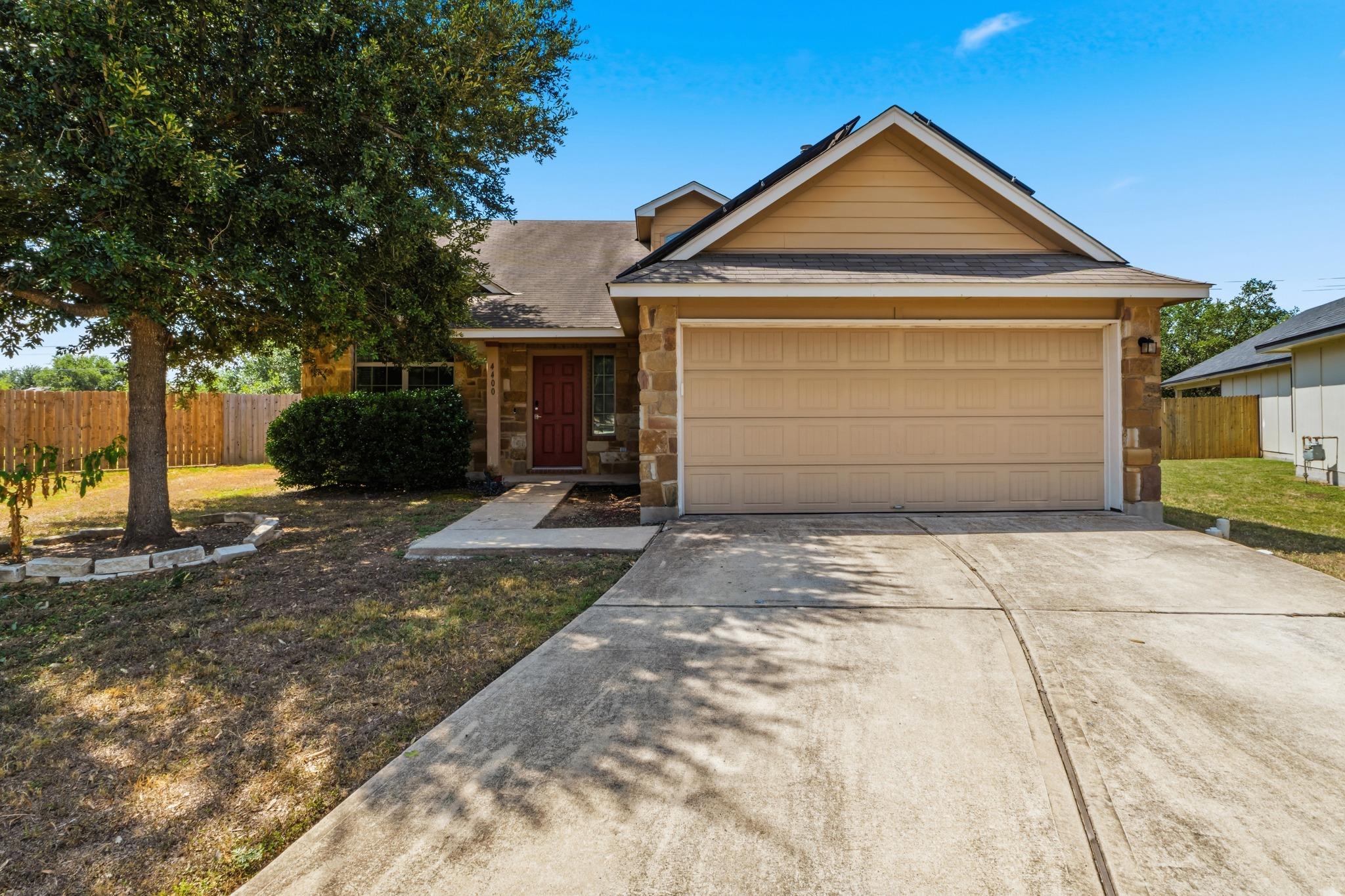 A concrete driveway leads to a two-car garage und