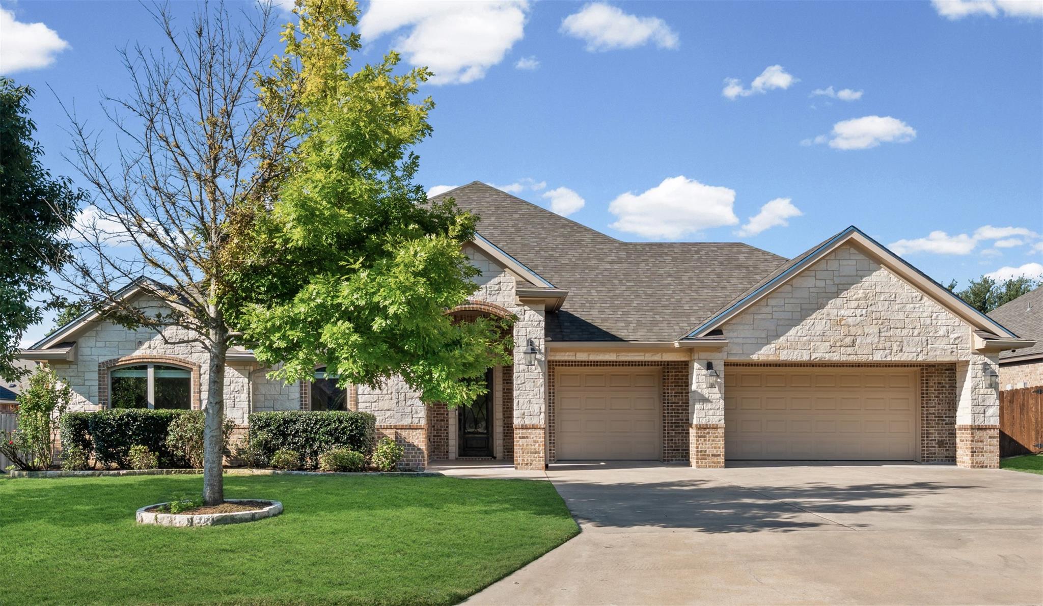 Textured stone siding and a multi-car garage defi