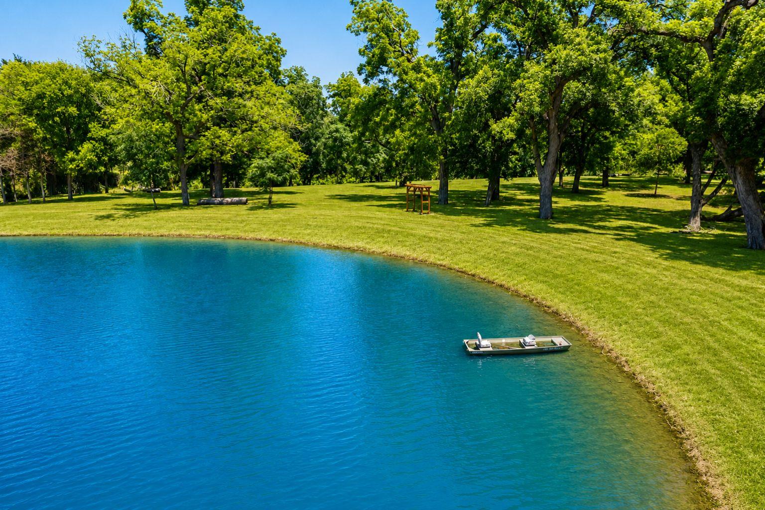 Mature trees frame a calm pond on this lush green