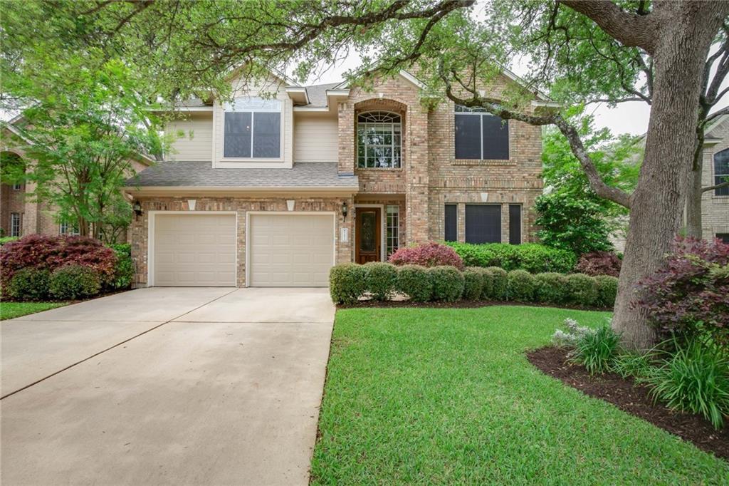 Mature trees frame a classic brick exterior compl