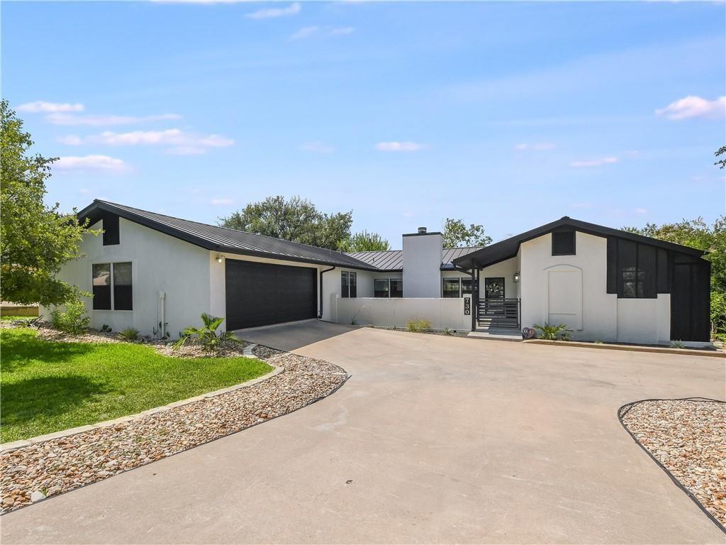 An expansive concrete driveway leads to this mode