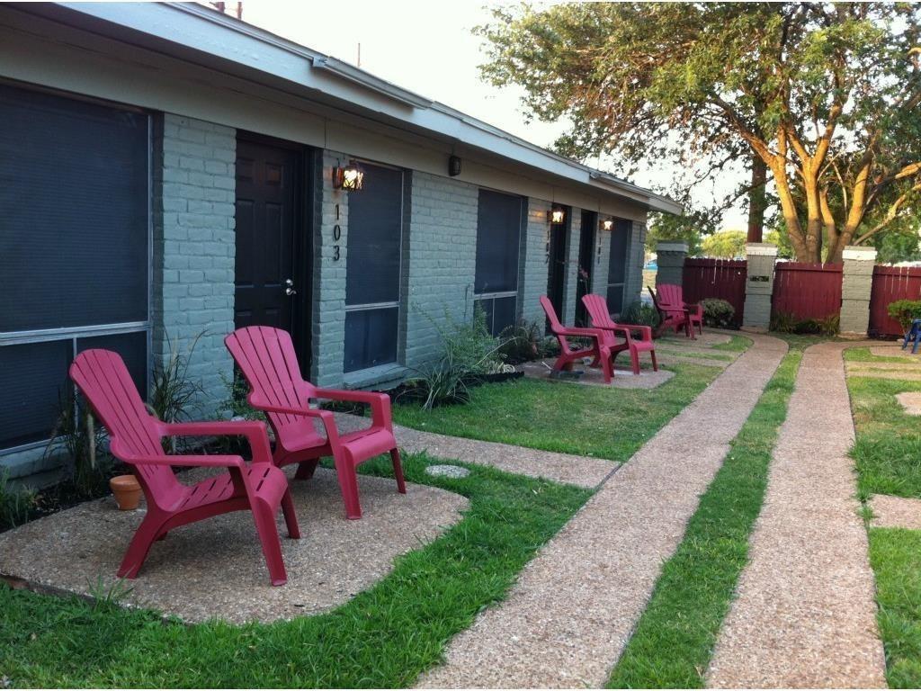 A well-maintained lawn and paved pathways lead al