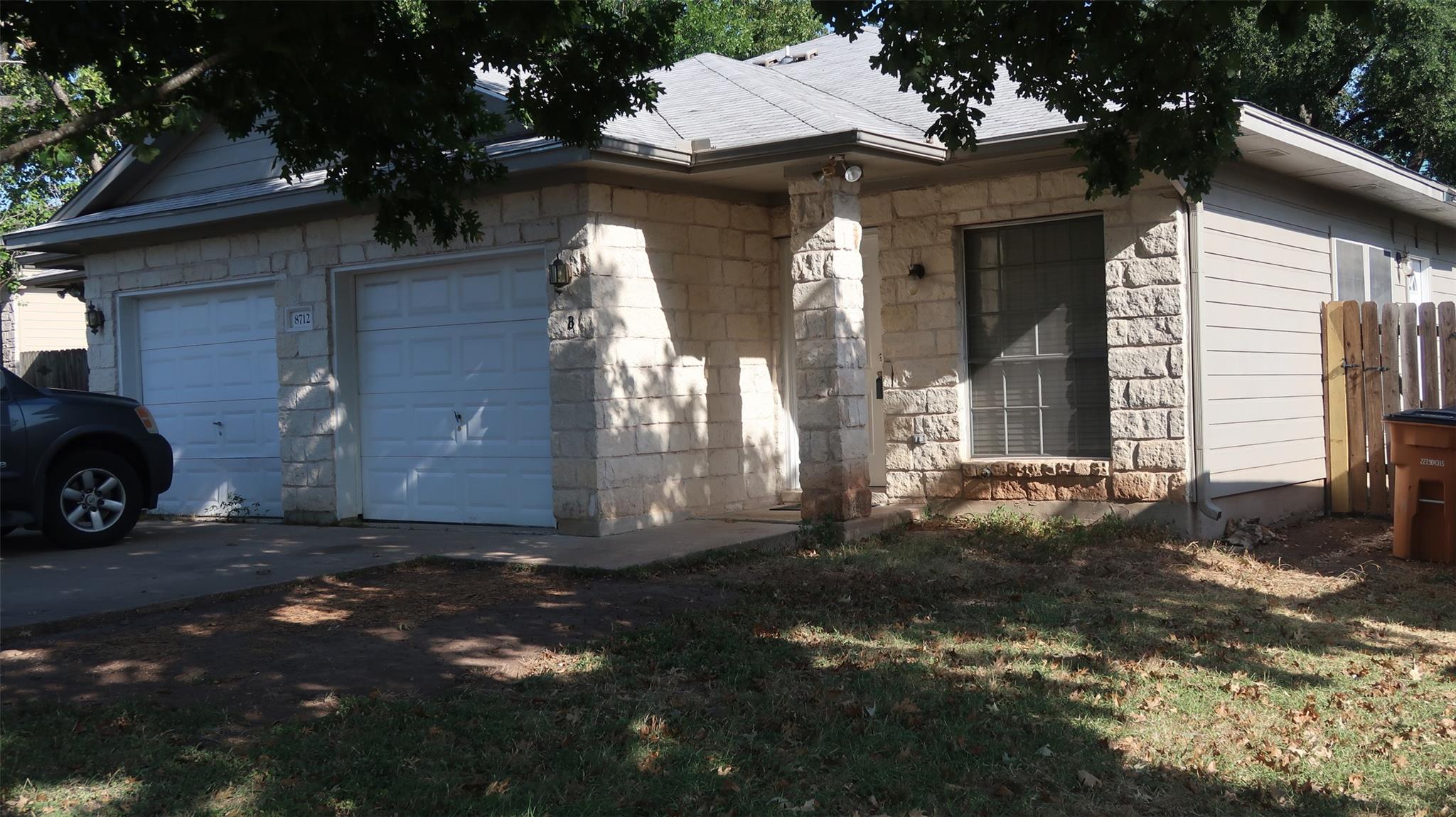 Natural stone accents and mature shade trees fram