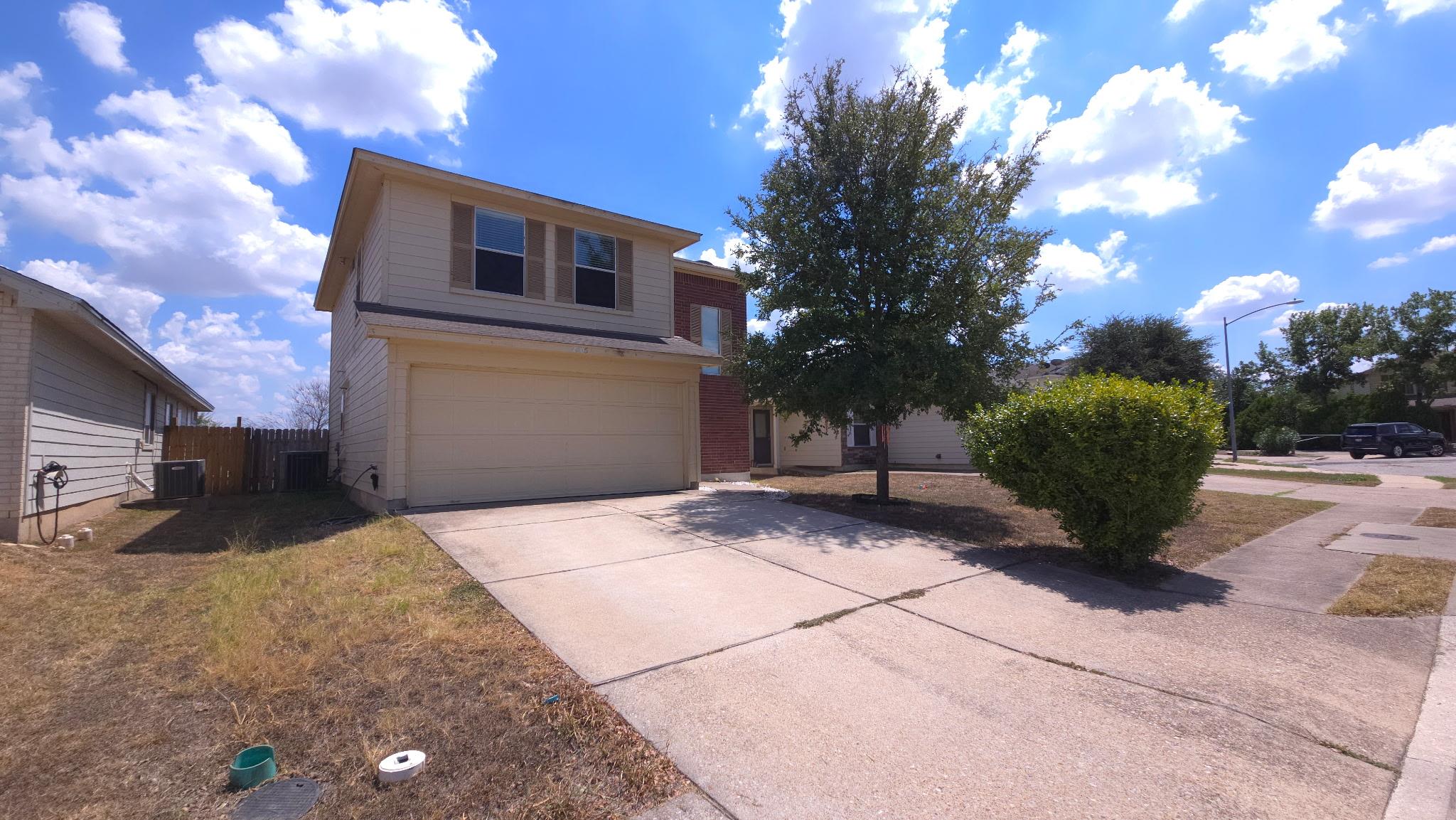 A spacious concrete driveway leads directly to th