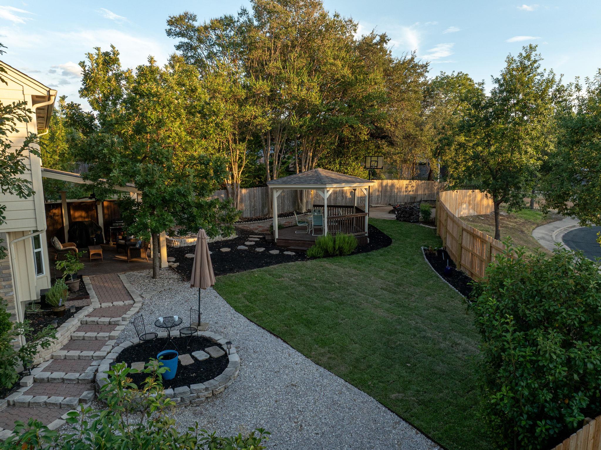 A spacious lawn and charming gazebo anchor this b