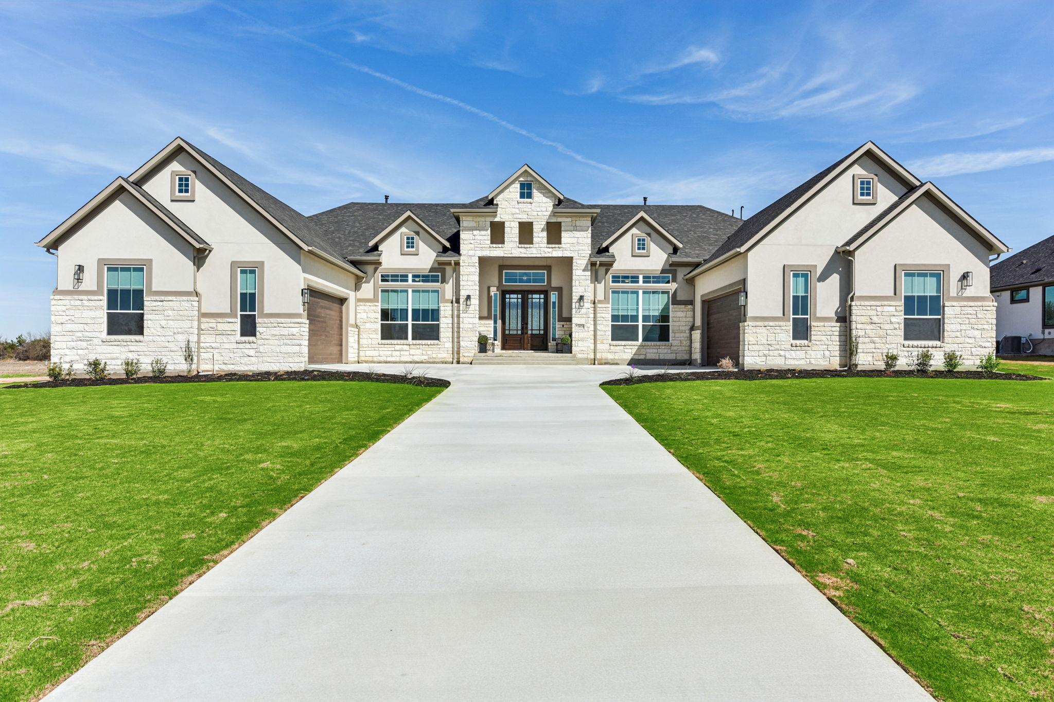 A long concrete driveway guides the eye toward th