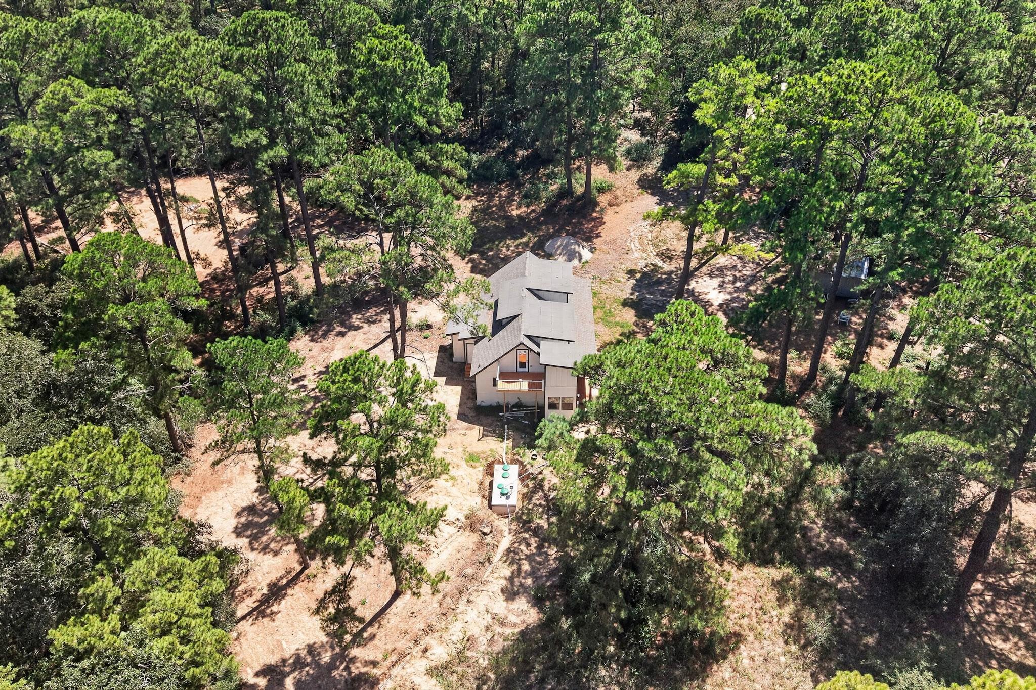 Mature pine trees envelop this private forest ret