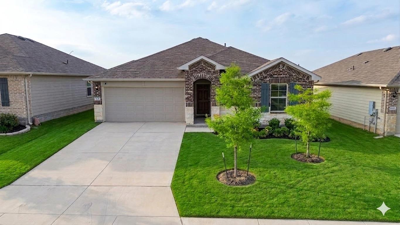 Brick facade with stone accents, a concrete drive