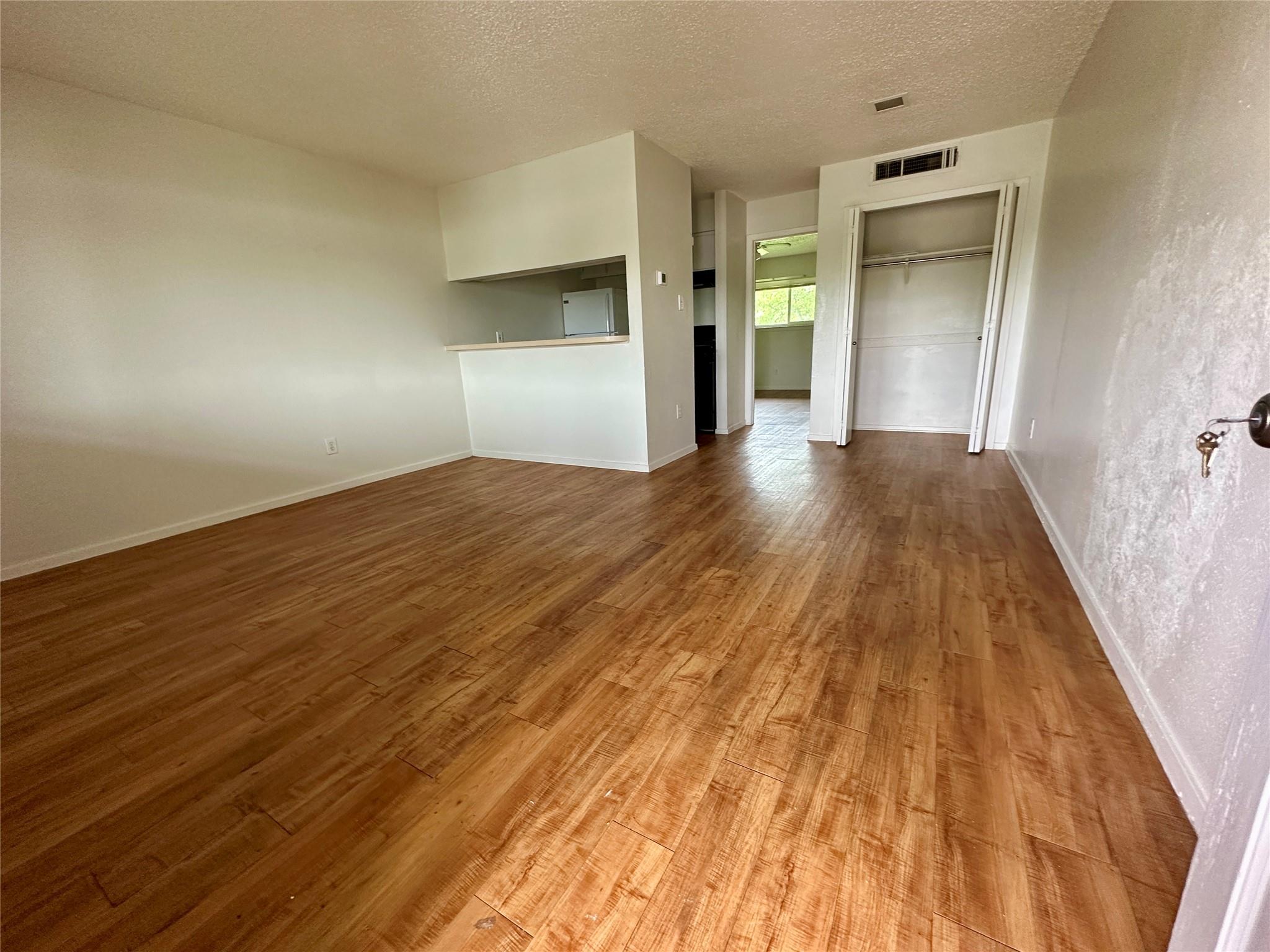 The living area features wood-look flooring and a