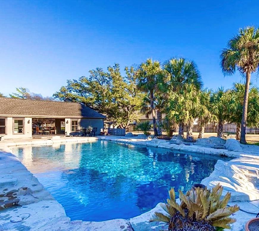 Mature palms and rugged stone borders frame this 