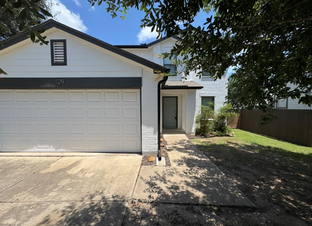 View of front of home with brick siding, an attac