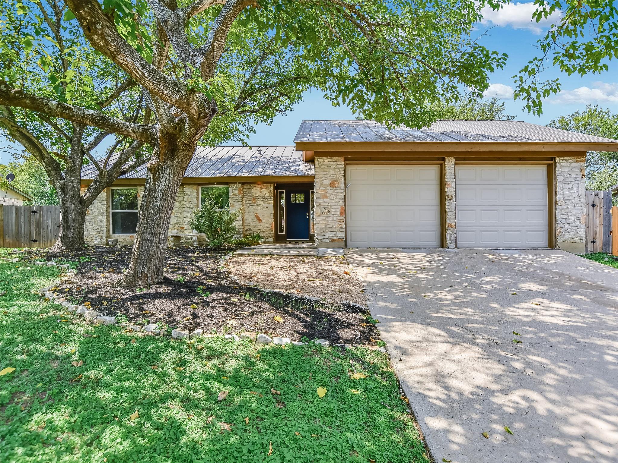 Mature trees shade a classic stone exterior with 