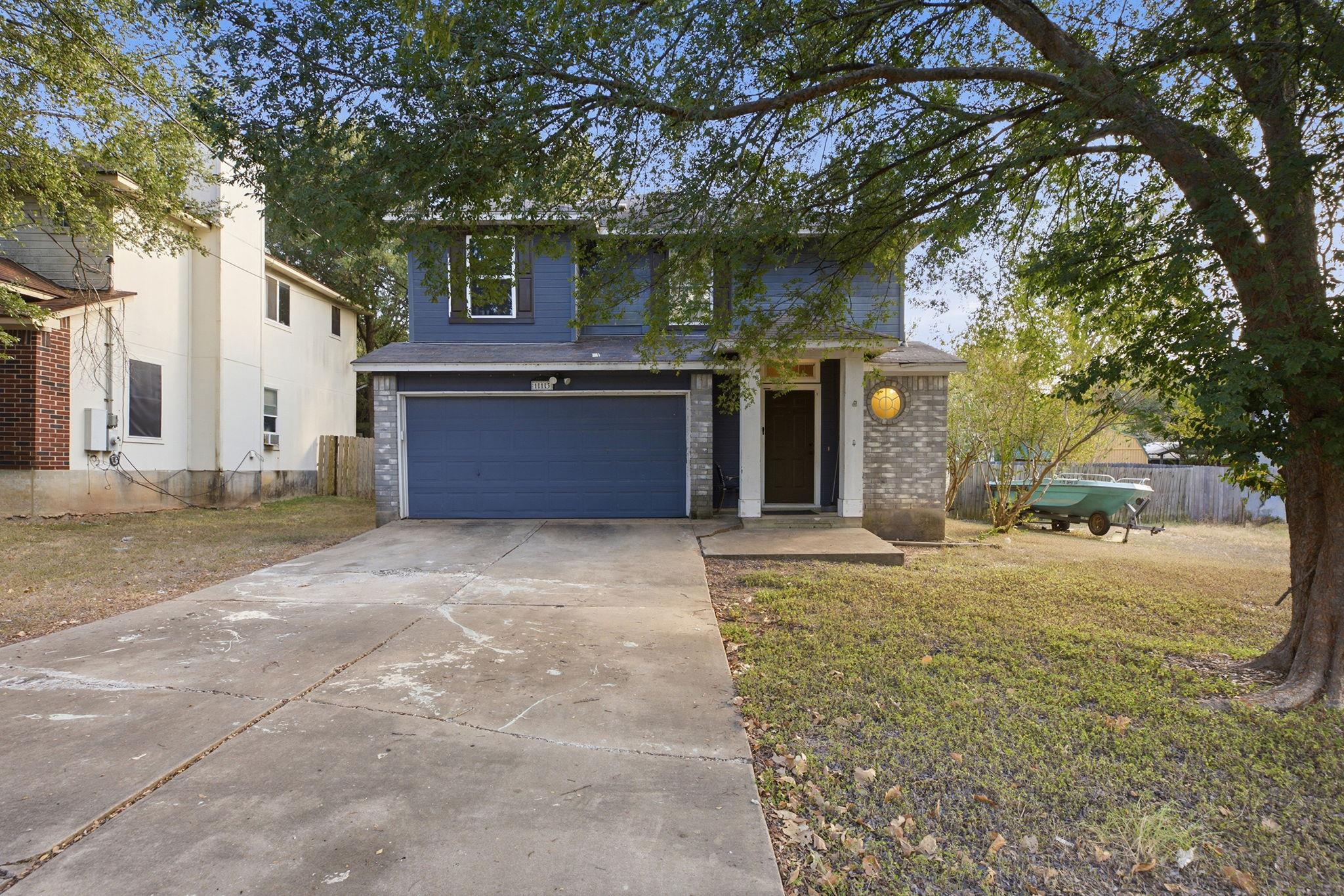 Mature trees shade the front lawn and concrete dr