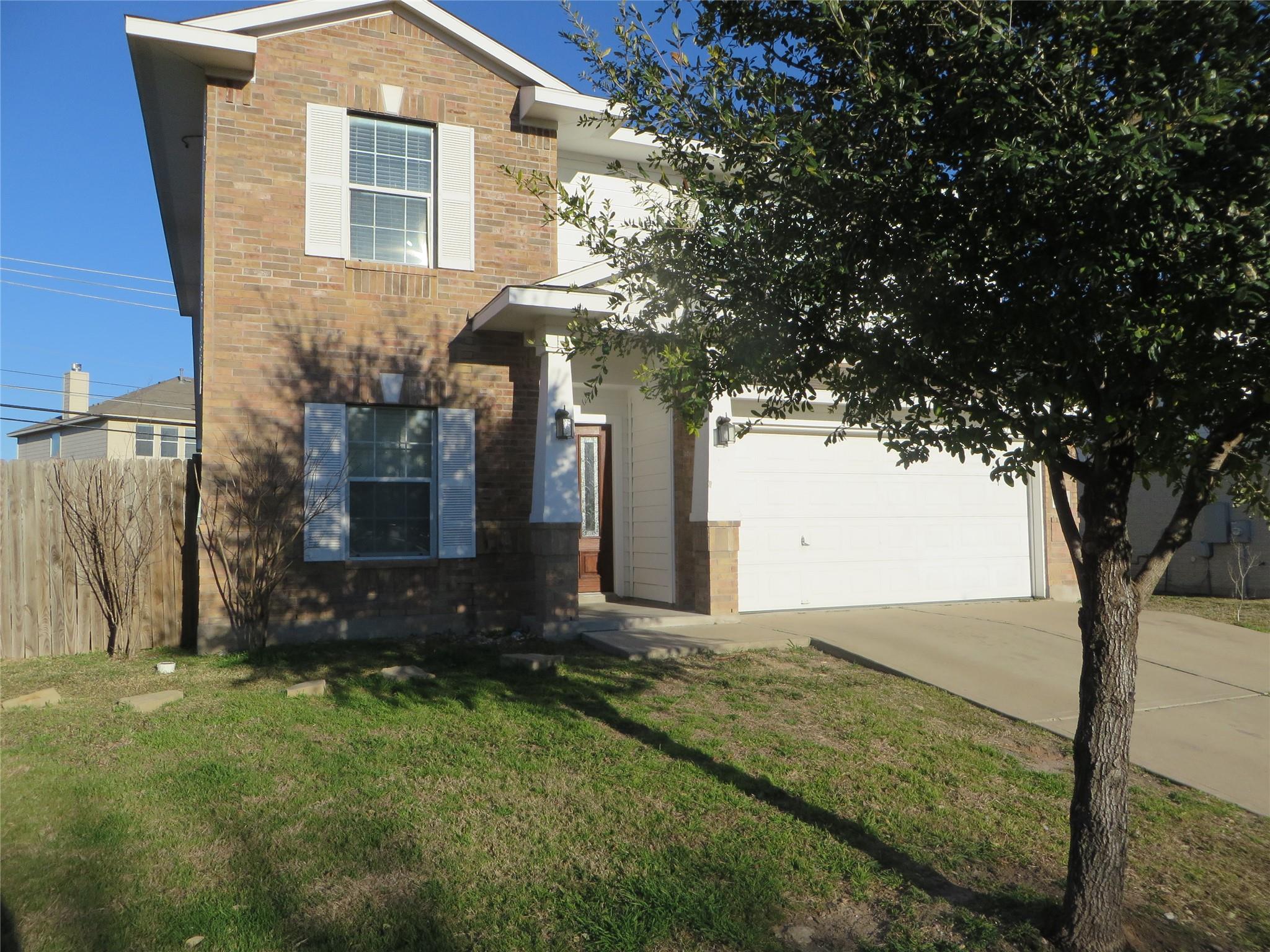 A classic brick exterior and concrete driveway de