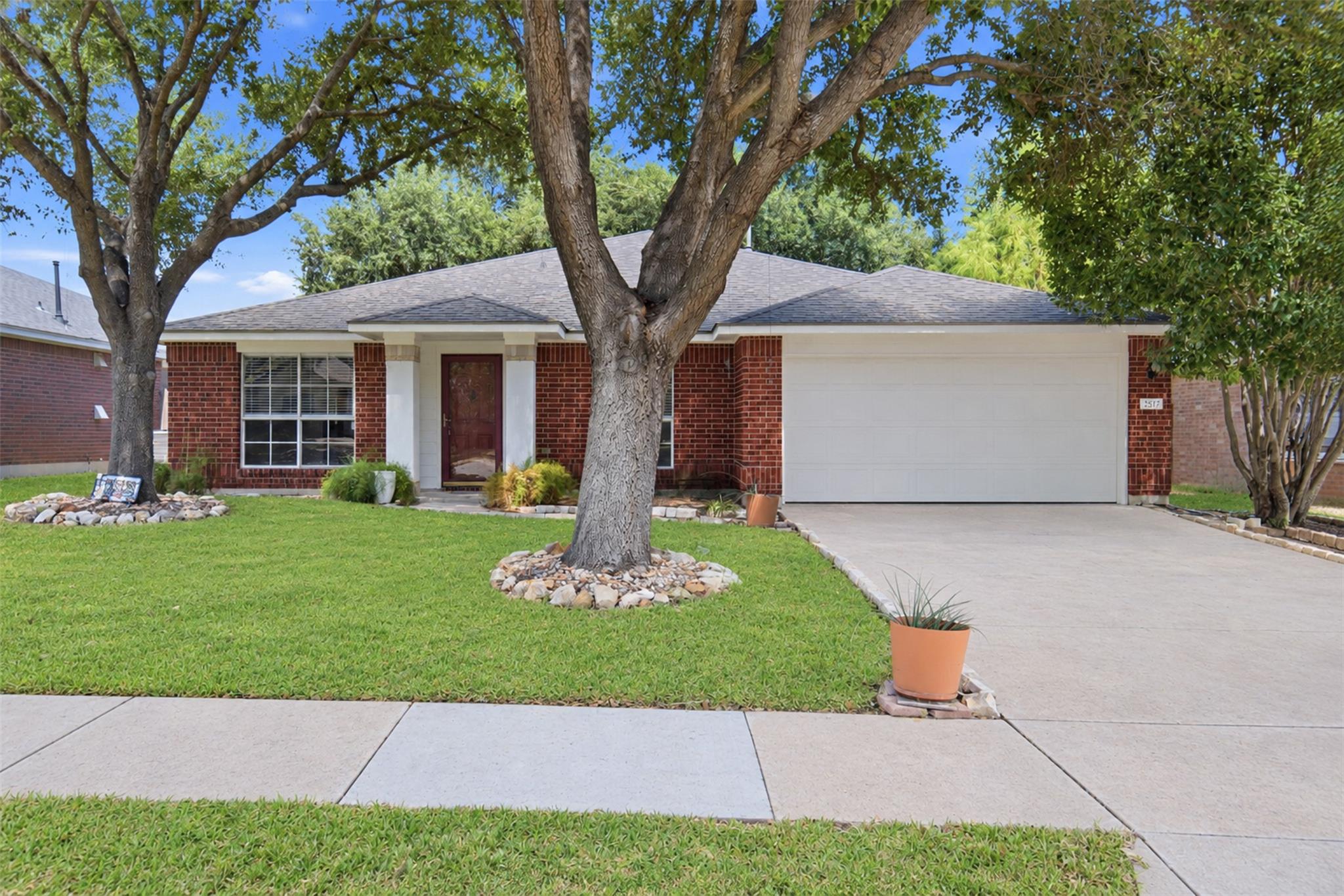 Mature shade trees frame a classic brick exterior