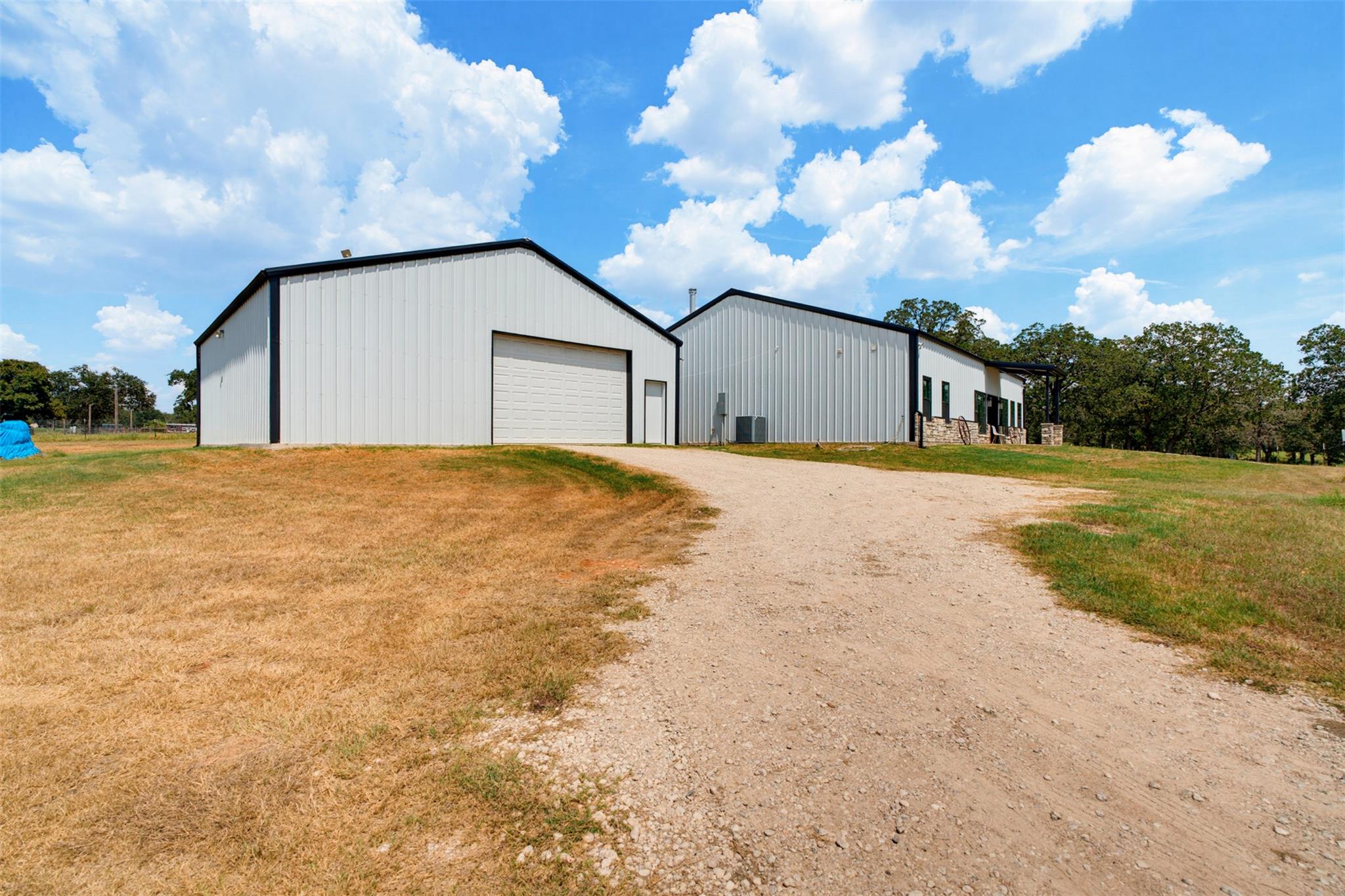 A long gravel driveway leads up to substantial me