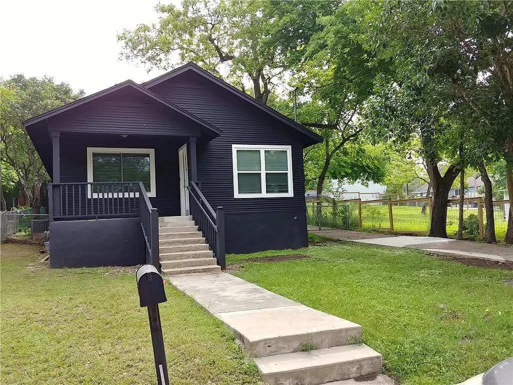 Crisp concrete steps lead to a covered porch and 