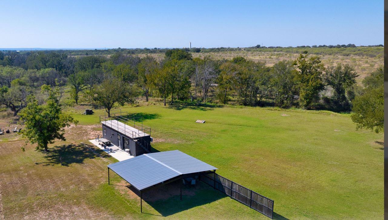 An expansive green lawn surrounds the modern stru