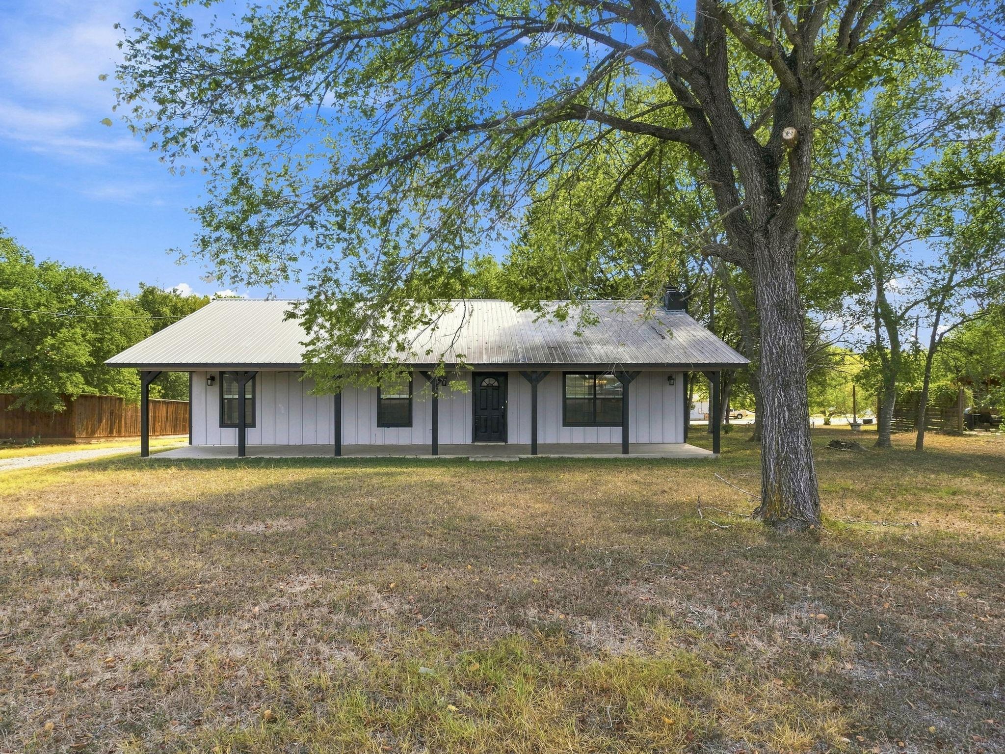 Mature trees shade a welcoming covered front porc