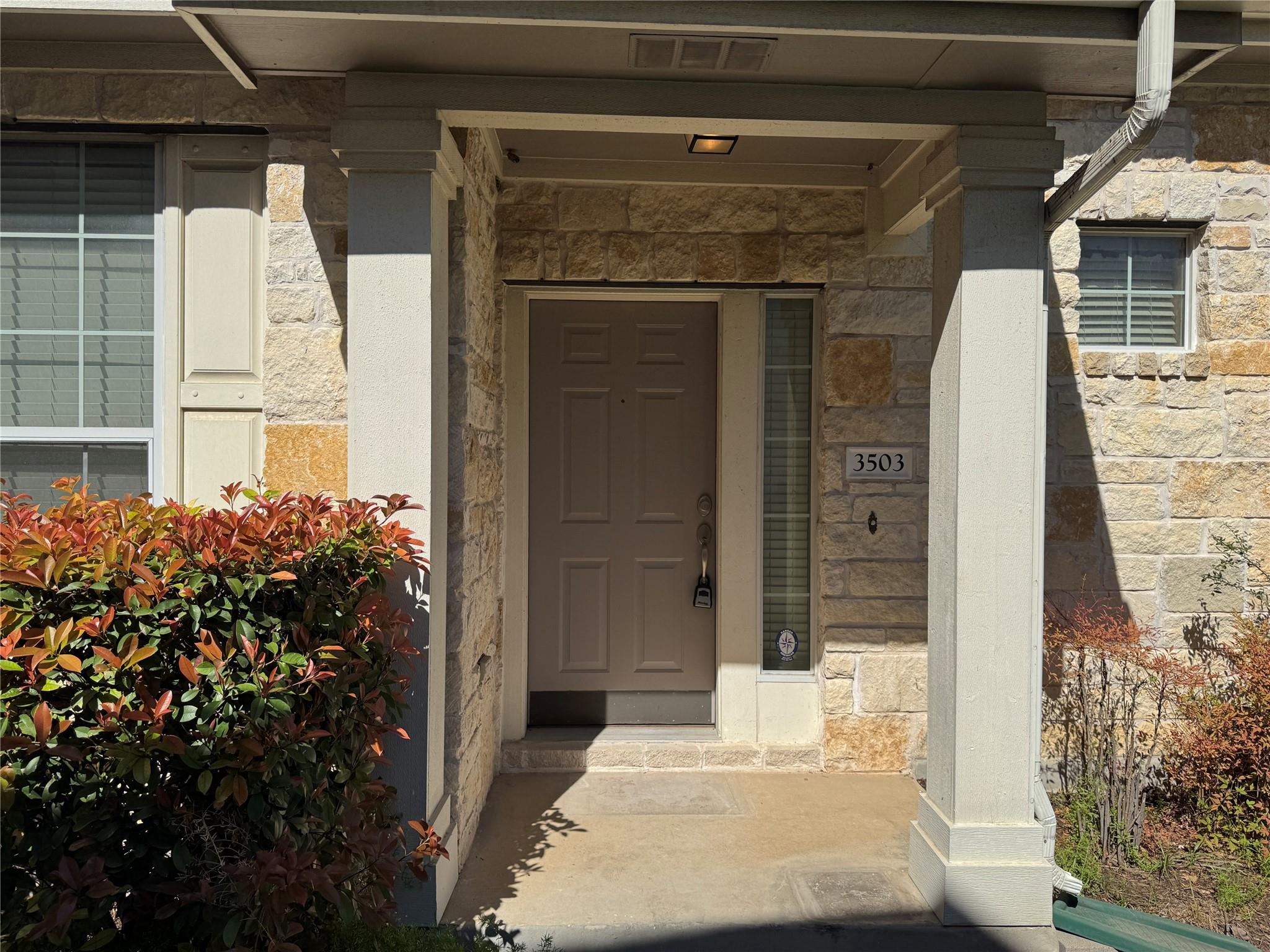 A sheltered stone entryway features prominent squ