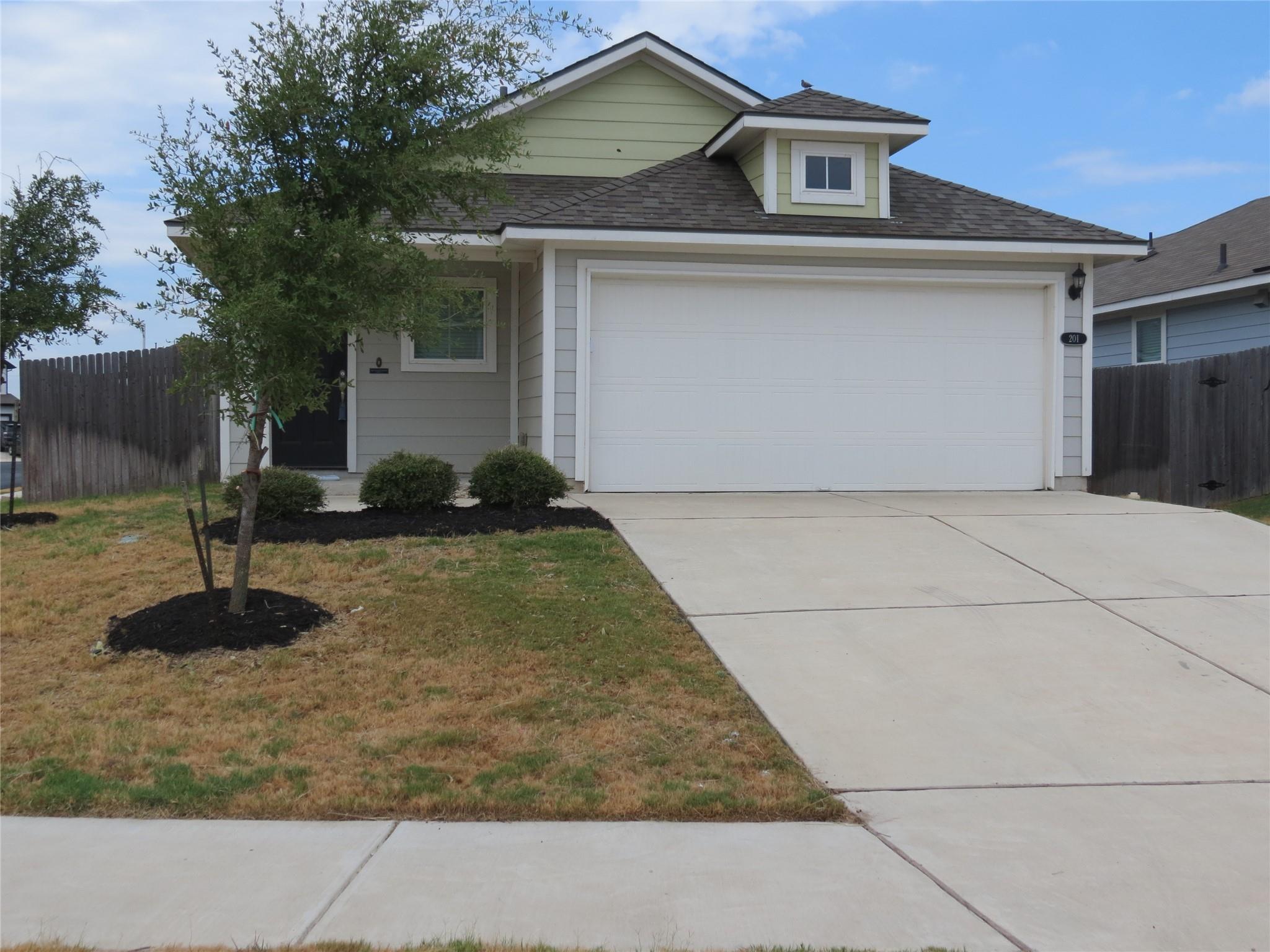 A spacious driveway and front-loading garage comp
