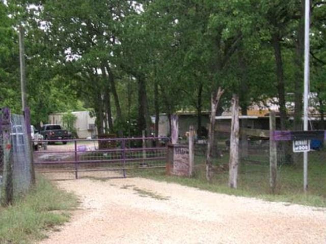A gated entry leads onto a wooded property border