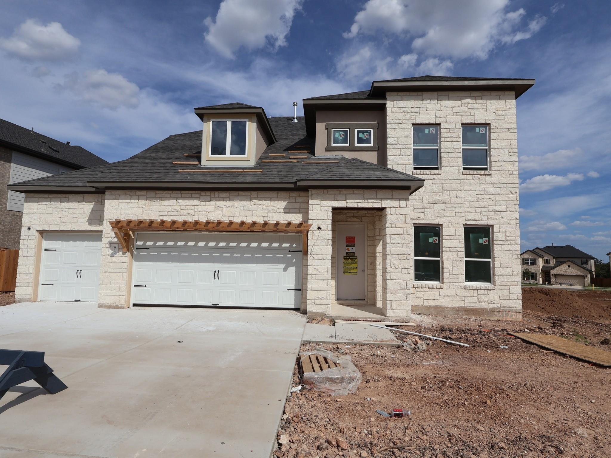 A light-colored stone facade and dark shingle roo