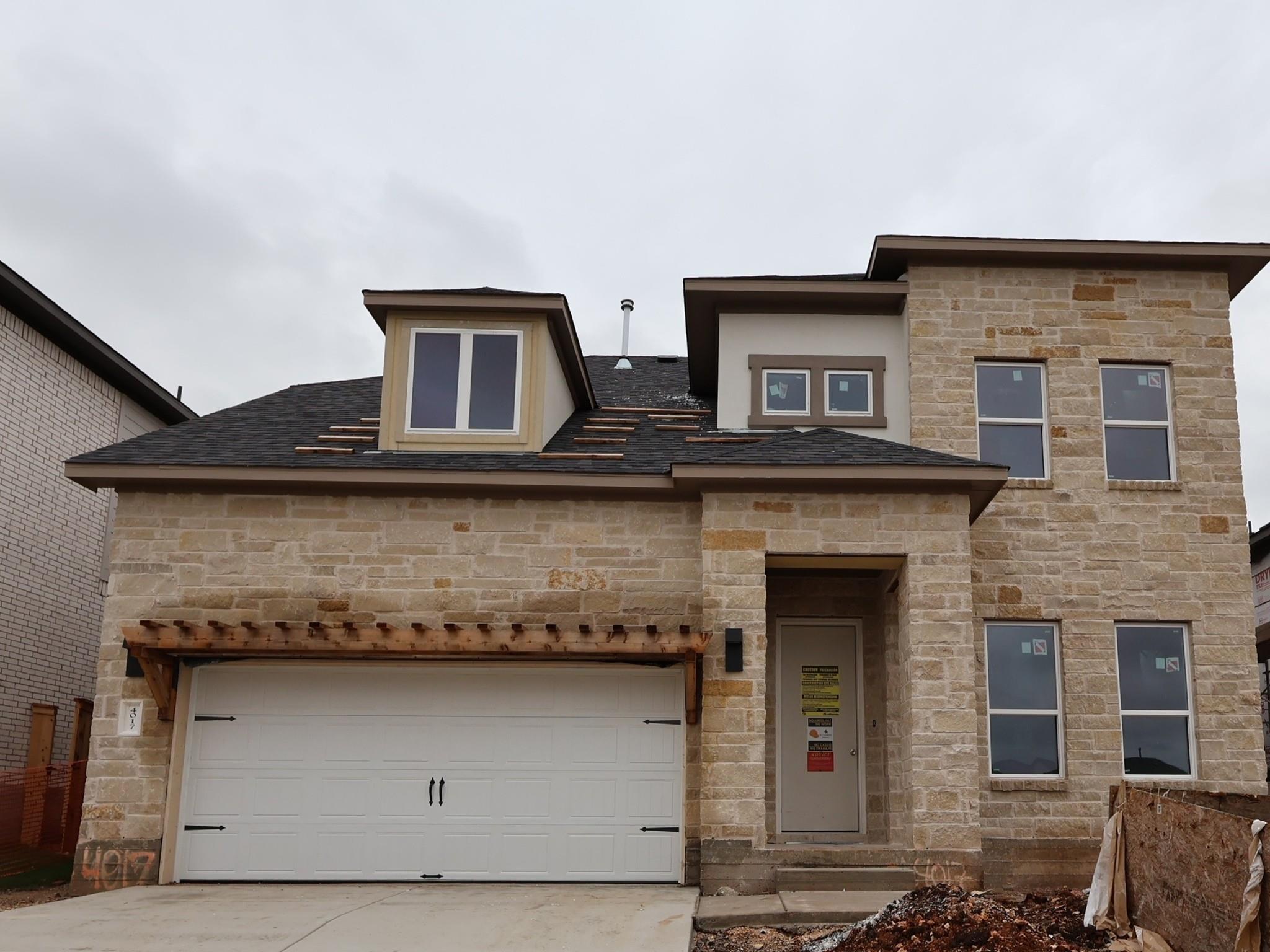 A striking stone facade highlights this modern tw