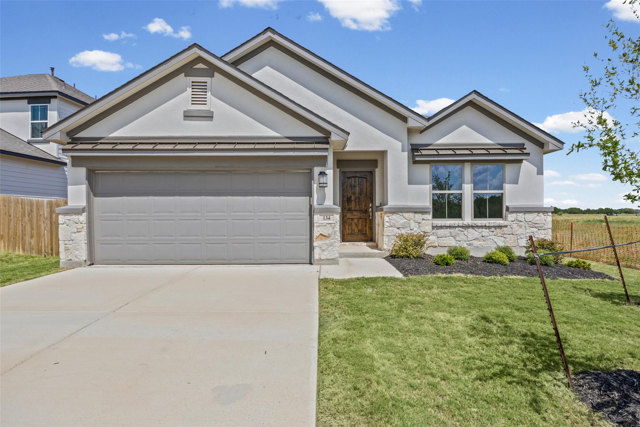 A classic stucco and stone exterior anchors this 
